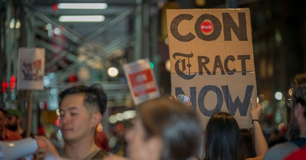 Participant seen holding a sign at the picket line outside...