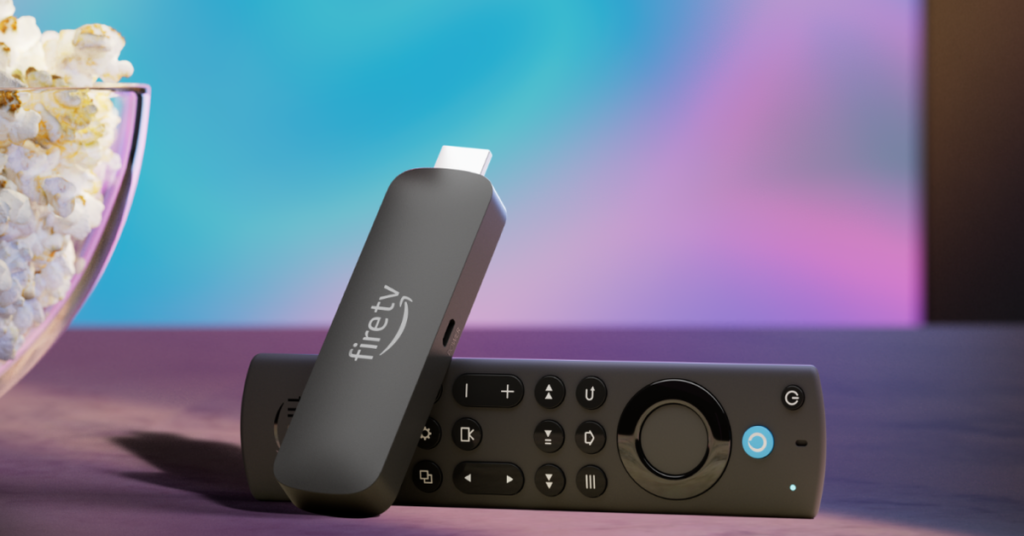 An Amazon Fire TV Stick 4K Max streaming stick with its remote sitting beside a bowl of popcorn in front of a TV.