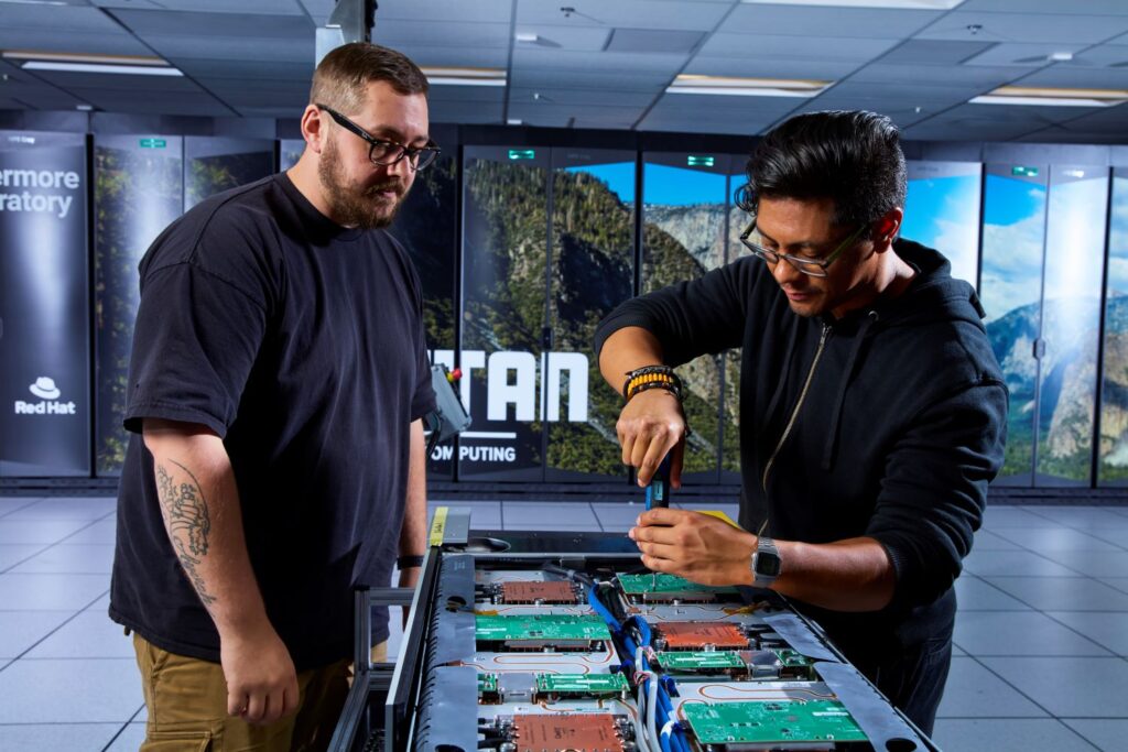 Lawrence Livermore National Laboratory technicians Gage Holcomb (left) and Raymond Lagoc service an El Capitan compute blade.