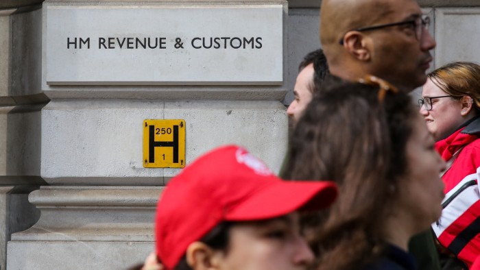 People walk past the HMRC building in central London