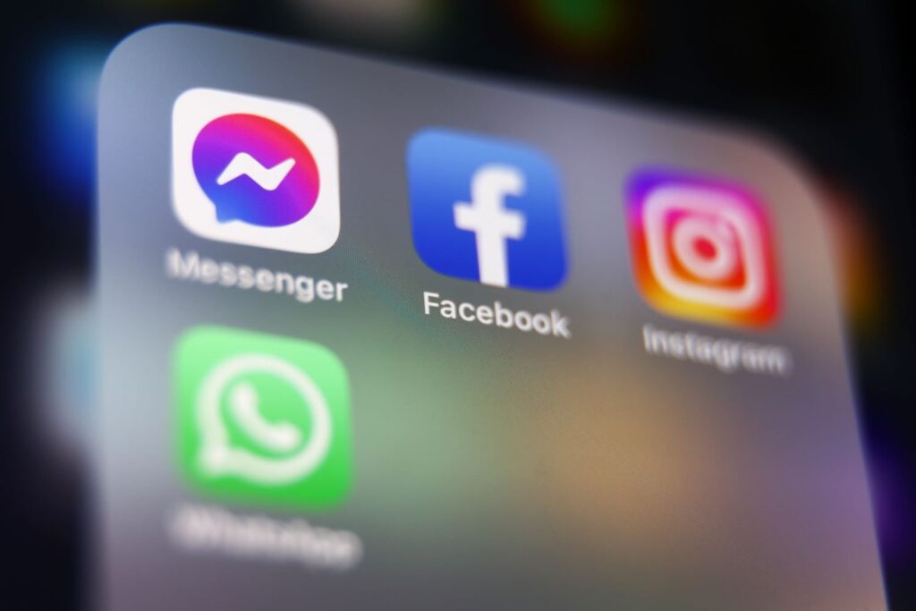 A phone screen showing the Messenger, Facebook, Instagram, and WhatsApp icons.