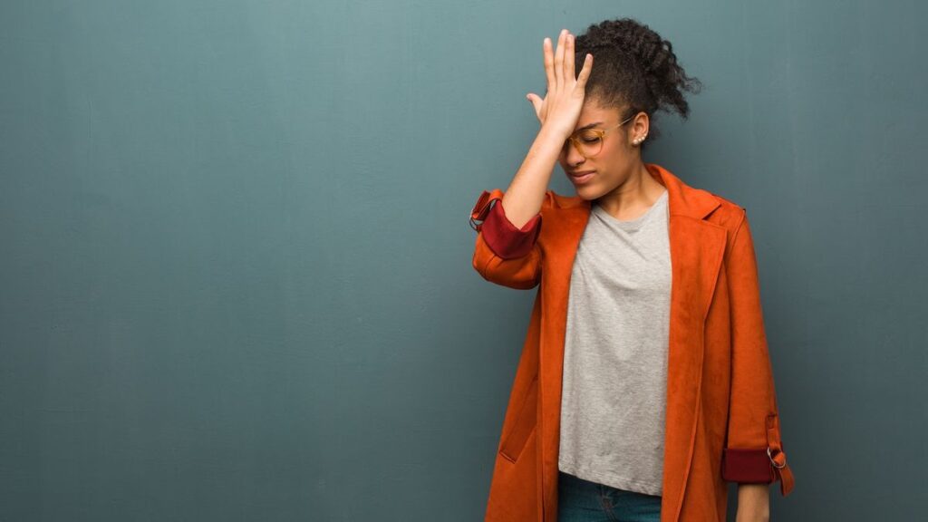 A young woman face-palms in frustration