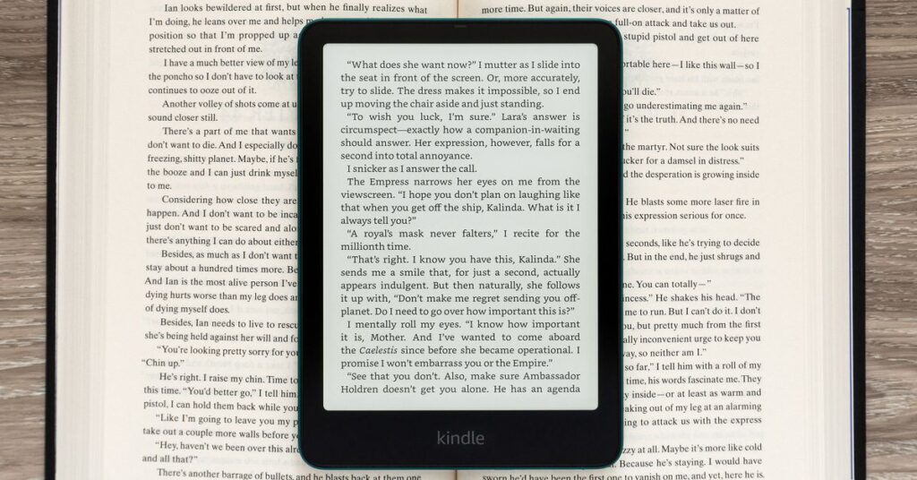 The Amazon Kindle Paperwhite Signature Edition (2024) displaying a page of text sitting on an open book.