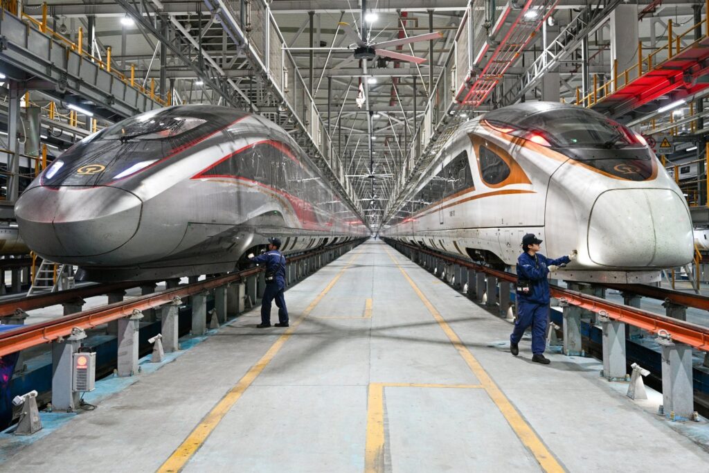 Mechanics check the conditions of high-speed trains at a maintenance base