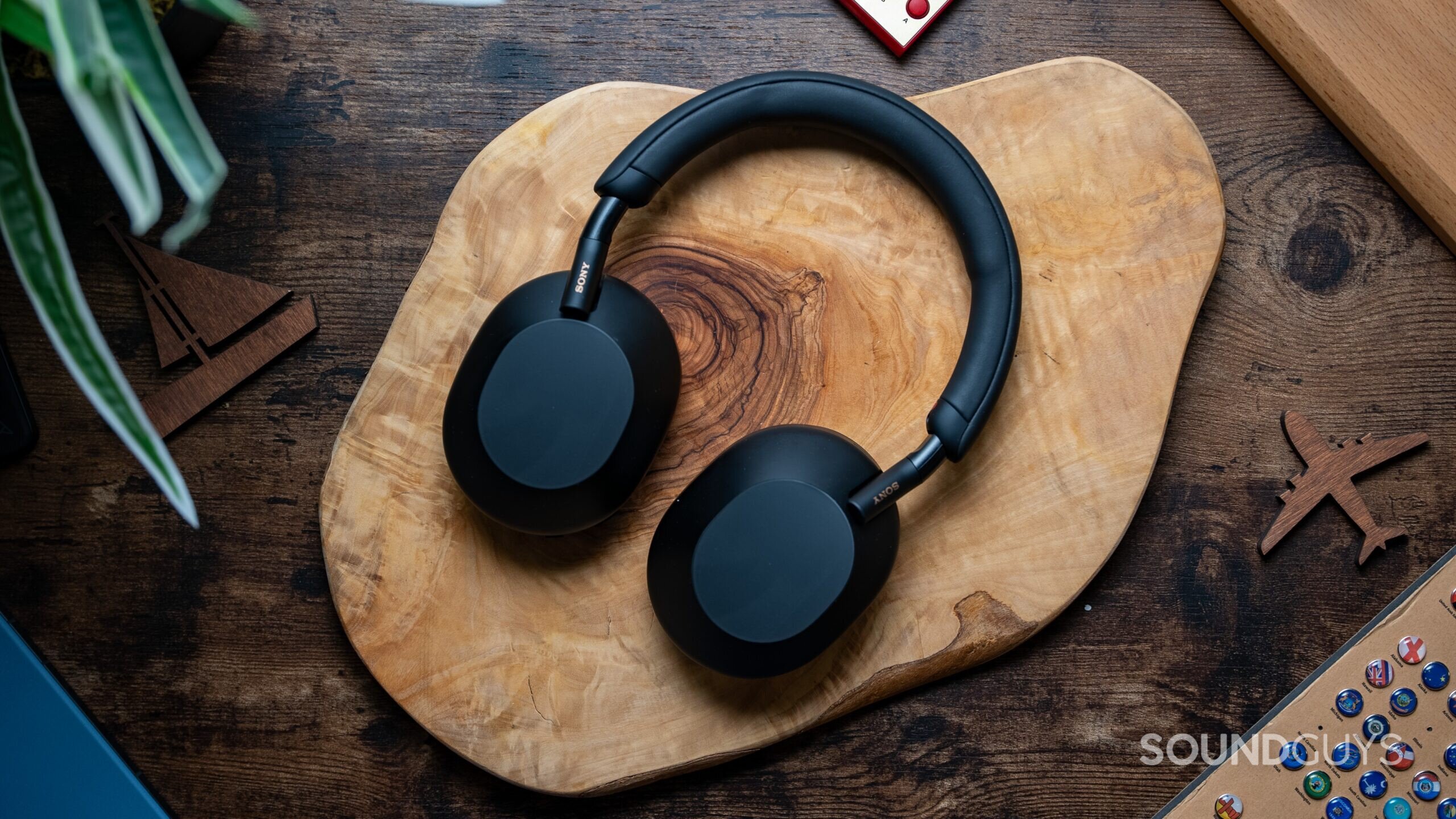 Sony WH 1000XM5 headphones laying flat on wooden table.