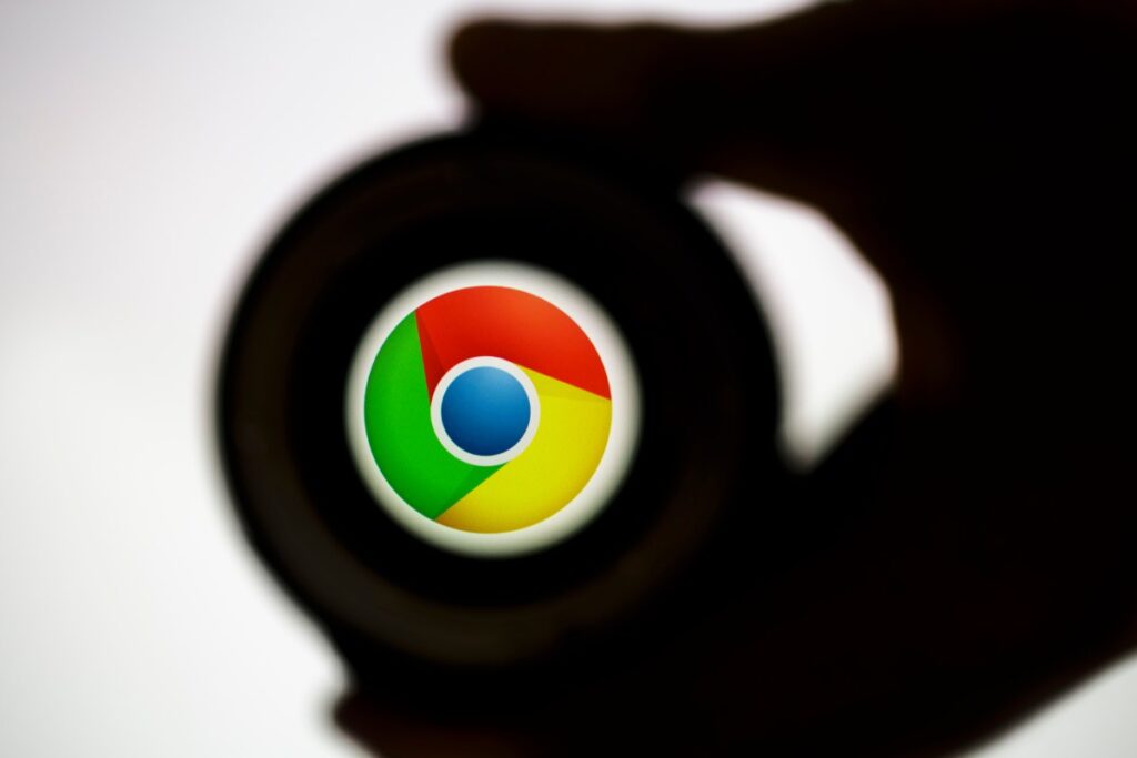 a google chrome logo in the distance surrounded by a shadowy hand