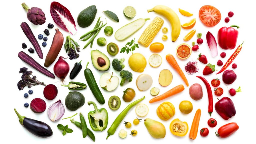 colorful fruits and vegetables on a white backround arranged in the order of the rainbow