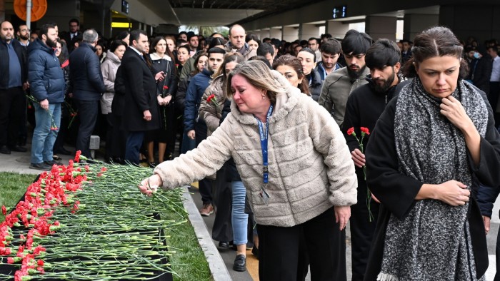 People lay flowers in memory of the victims of the Azerbaijan Airlines plane crash