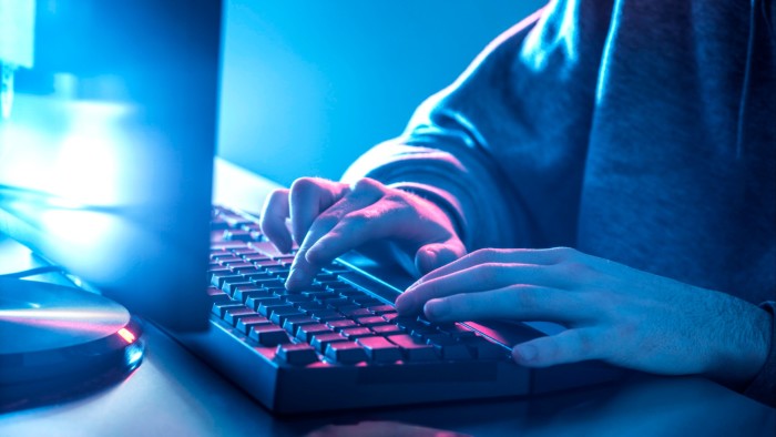 Young man using the internet on his computer at his desk.